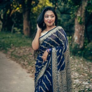 Graceful woman in a traditional saree poses in a natural setting in Comilla, Bangladesh.