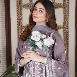 Fashion model showcasing traditional Pakistani attire with floral accents indoors.