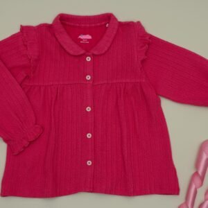 A vibrant pink long sleeve blouse with decorative elements, perfect for children's fashion.